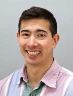 Dr. Torres smiles into the camera wearing a light blue and pink button up. 