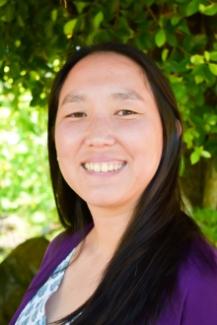 Dr. Timmerman smiles for a headshot in a purple sweater and white shirt. 