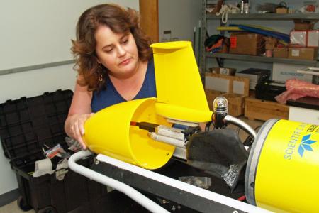 UGA Skidaway Institute researcher Catherine Edwards examines the tail assembly of a glider.
