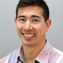 Dr. Torres smiles into the camera wearing a light blue and pink button up. 