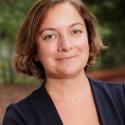 Dr. Aslan smiles for a headshot in a navy blazer with a white and navy blouse. 