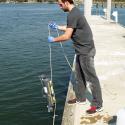 UGA Skidaway Institute grad student Sean Anderson collects a water sample from the Skidaway River. 